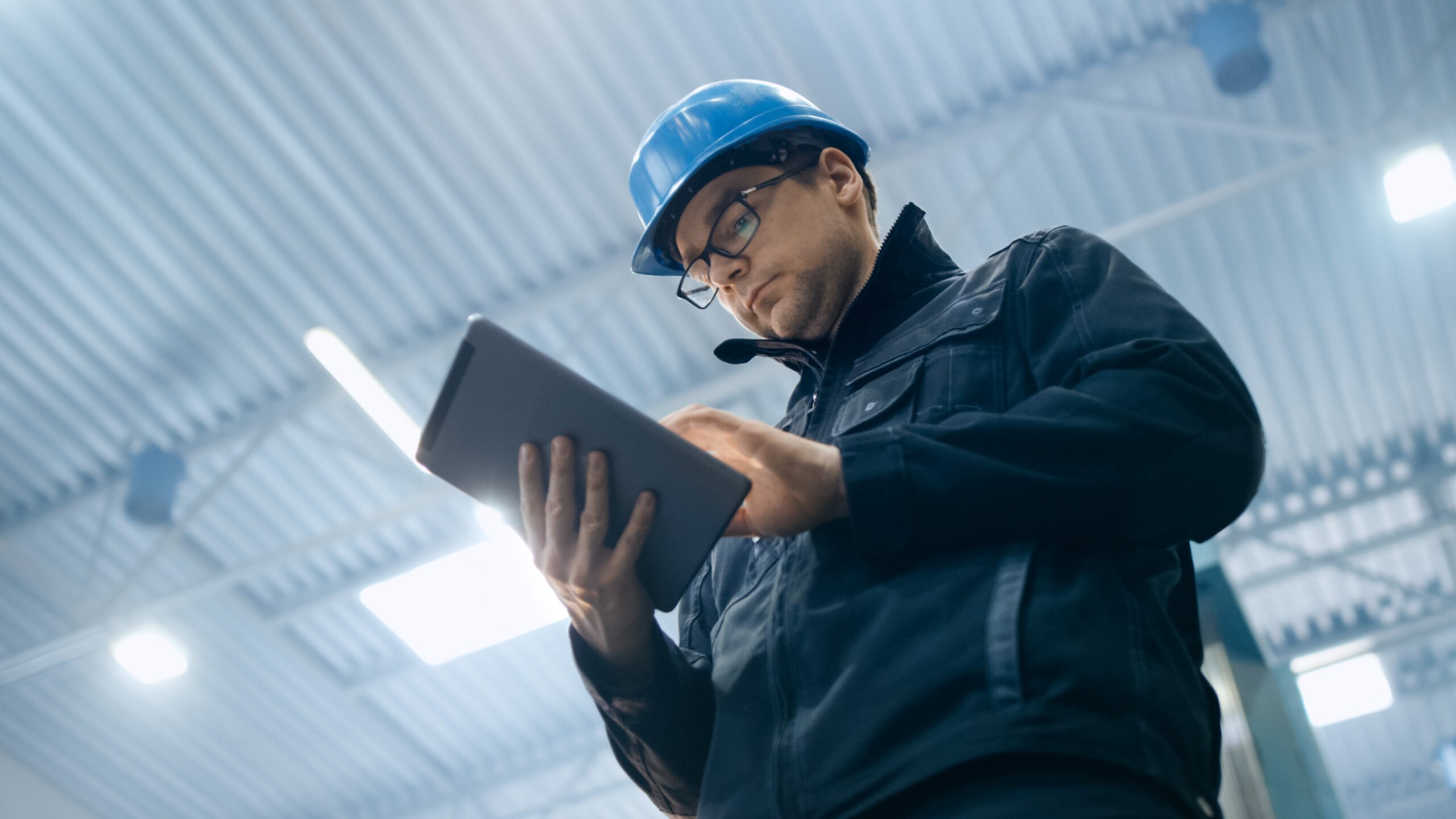 Factory,Worker,In,A,Hard,Hat,Is,Using,A,Tablet Cityworks Issue Tracking
